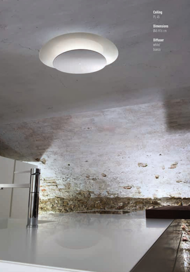 I dischi in vetro curvato riflettono la luce della sorgente centrale creando in questo modo un’illuminazione diffusa e indiretta. La lampada esiste nella finitura bianca o foglia oro.